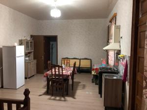 Il comprend une cuisine et une salle à manger avec une table et un réfrigérateur. dans l'établissement Guest house, à Zugdidi