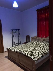 - un lit dans une chambre dotée d'un rideau rouge dans l'établissement Guest house, à Zugdidi