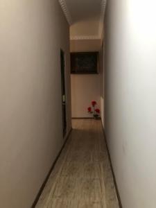 un couloir vide avec un mur blanc et du parquet dans l'établissement Guest house, à Zugdidi