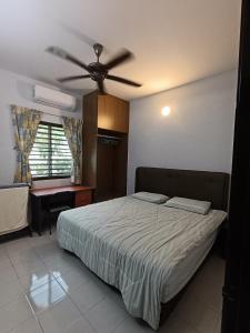Schlafzimmer mit einem Bett und einem Deckenventilator in der Unterkunft Lim Garden Homes in Balik Pulau