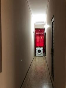 un couloir avec un lave-linge et un rideau rouge dans l'établissement Guest house, à Zugdidi