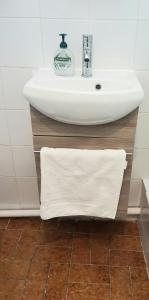toalla blanca debajo de un lavabo en el baño en F2 meublé RER B La Place/ Gentilly, proche 75014, Parking libre, CC Vache Noir, Complexe Sportif Raspail en Arcueil