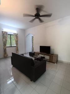 ein Wohnzimmer mit einem Sofa und einem Deckenventilator in der Unterkunft Lim Garden Homes in Balik Pulau