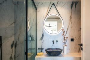 a bathroom with a bowl sink and a mirror at RIRIKA Beach Living, New Seaside Apartments in Plakias in Plakias +48 photos