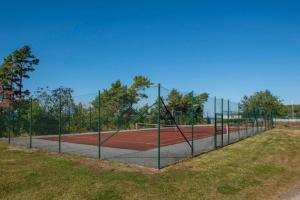 una pista de tenis con una valla alrededor en Visby Snäck Lägenheter, Havsutsikt, en Visby