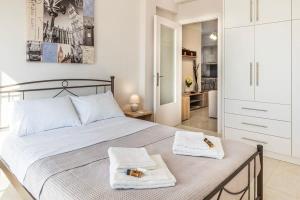 a bedroom with a large bed with towels on it at Comfy Central Square Gem with Balcony in Kalamata