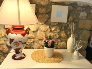 un tavolo con una lampada e un vaso con fiori di Circeii a San Felice Circeo