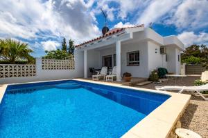 a villa with a swimming pool in front of a house at Chalet El Garxal Riumar Pura Natura in Riumar