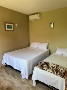 duas camas sentadas uma ao lado da outra num quarto em Luamar Chalés em São Miguel do Gostoso