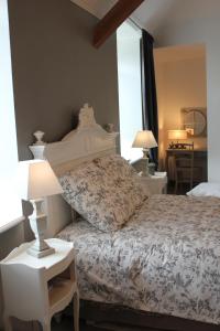 a bedroom with a bed and a table with lamps at Le Presbytère de Sévigny in Sévigny-Waleppe