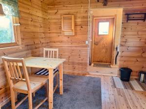 ein Esszimmer mit einem Tisch und Stühlen in einer Blockhütte in der Unterkunft Sam Arctic in Övertorneå