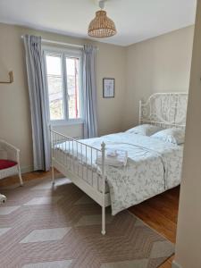 a bedroom with a white bed and a window at Maison Rouge in Montagne