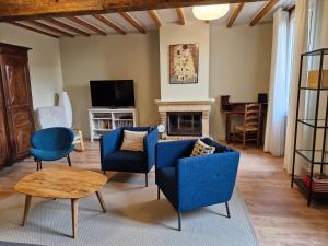a living room with blue chairs and a fireplace at Maison Rouge in Montagne