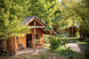赫伯格的住宿－CityKamp Colmar，树林中的小屋,配有桌子和椅子
