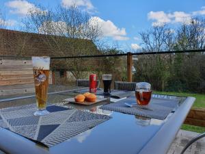 a table with two glasses of beer and oranges on it at Chambres d'hôtes Villa Honorine in Saint-Honoré-les-Bains