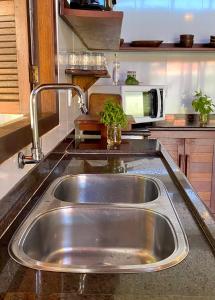 fregadero de acero inoxidable en una cocina con microondas en Espaçoso 4qd, Privado casa com Piscina, Love Beach, Pipa, en Pipa