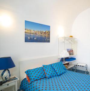 - une chambre dotée d'un lit avec des draps bleus en points de polka dans l'établissement Maridea, à Procida
