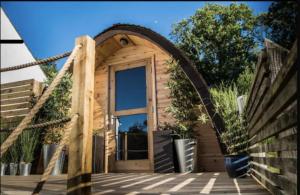 una pequeña casa de madera con una puerta grande en Beautiful 1-Bed Chalet in Tenby, en Tenby