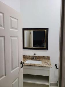 a bathroom with a sink and a mirror at Beachscape At Black River in Black River