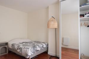 a small bedroom with a bed and a lamp at Refurbished love nest on Montmartre hilltop in Paris