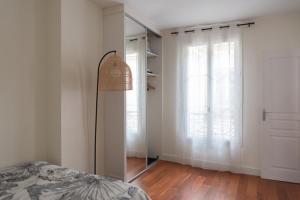 a bedroom with a bed and a mirror and a window at Refurbished love nest on Montmartre hilltop in Paris