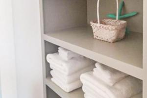 a shelf filled with towels and a basket at Tybee Stars in Tybee Island +16 photos