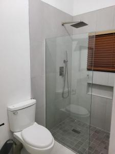 a bathroom with a toilet and a glass shower at Beachscape At Black River in Black River