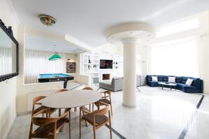 un soggiorno con tavolo e tavolo da biliardo di Vouliagmeni Athenian Riviera Villa ad Atene