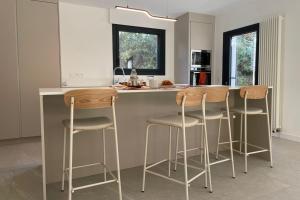 une cuisine avec un îlot avec trois tabourets de bar dans l'établissement Minimalist house with pool, aux Angles (Gard)