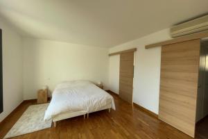 - une chambre blanche avec un lit et un placard dans l'établissement Minimalist house with pool, aux Angles (Gard)