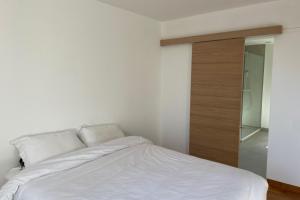 - une chambre avec un lit blanc et une porte en bois dans l'établissement Minimalist house with pool, aux Angles (Gard)