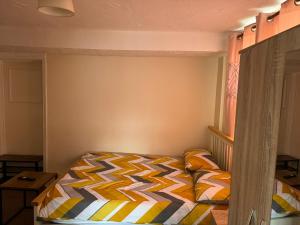 um quarto com uma cama com um edredão colorido em One Bedroom Flat with on premises parking em Walsall