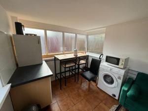 a small kitchen with a table and a washing machine at One Bedroom Flat with on premises parking in Walsall