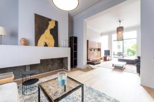 a living room with a fireplace and a table at Rez/duplex 3 ch et jardin in Brussels
