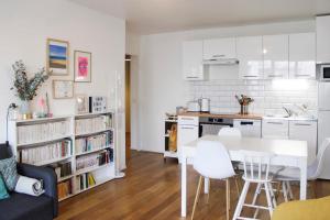 a kitchen and living room with a white table and chairs at Spacious family nest near La Villette in Pantin
