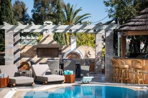 uma piscina com cadeiras e um gazebo em Vouliagmeni Athenian Riviera Villa em Atenas