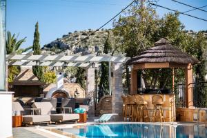 uma piscina com um gazebo ao lado de uma casa em Vouliagmeni Athenian Riviera Villa em Atenas