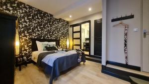 a bedroom with a bed with a black and white patterned wall at Le Presbytère de Sévigny in Sévigny-Waleppe