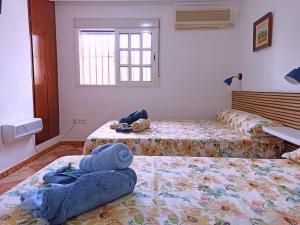 1 dormitorio con 2 camas y toallas en el suelo en El Azahar, en Sevilla