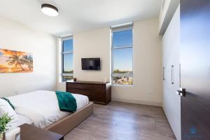 a bedroom with a bed and a flat screen tv at Rooftop Pool- Gym - Hollywood Beach Broad - walk in Hollywood