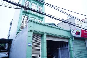 a green and white building on a street at Hanoi Delight House in Hanoi