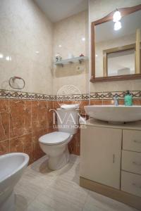 a bathroom with a sink and a toilet and a mirror at Casa Gabriela Ivan Luxury Homes 2ªPlta Norte in Castellón de la Plana +12 photos