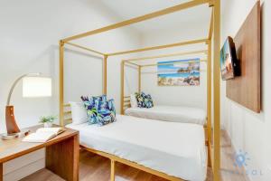 1 Schlafzimmer mit 2 Betten mit Baldachin und einem Schreibtisch in der Unterkunft Best Stay - Rooftop Pool - Broad - walk - Near Beach in Hollywood