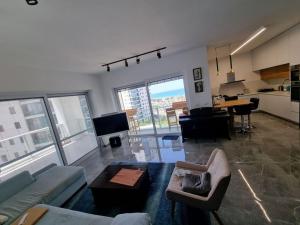 a living room with a couch and a table at Beach front luxury apartment - managed building in H̱adera