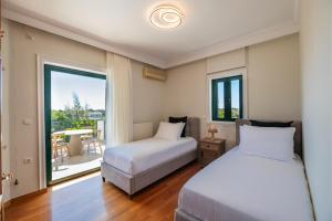 um quarto com 2 camas e uma varanda em Vouliagmeni Athenian Riviera Villa em Atenas
