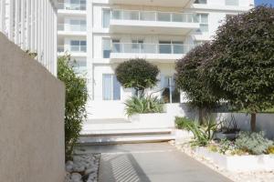 a view of a building with trees and plants at Beach front luxury apartment - managed building in H̱adera