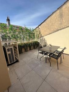 a table and chairs sitting on top of a patio at Appartement élégant, 2 chambres et terrasse Rofftop in Montélimar
