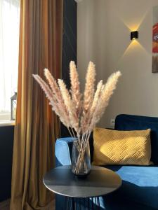 un jarrón con flores sobre una mesa en la sala de estar en Fashion Apartment en Narva