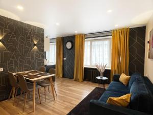 a living room with a blue couch and a table at Fashion Apartment in Narva