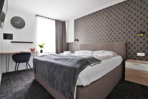 a bedroom with a bed and a desk and a clock at Stilvolle Apartments in Bonn I home2share in Bonn